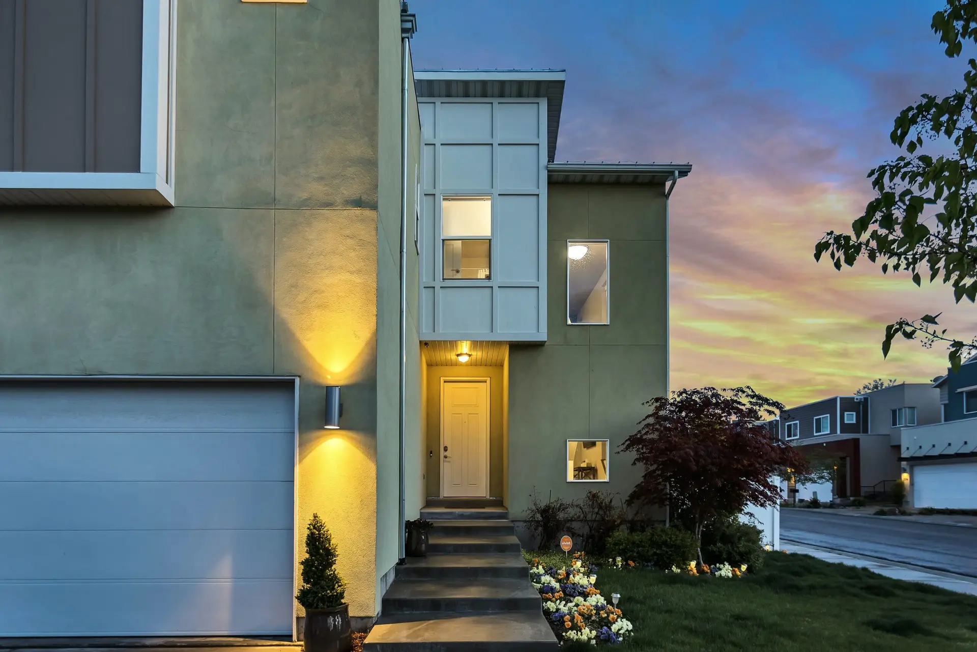 Exterior of a well-lit home at sunset, secured by APS home security system.