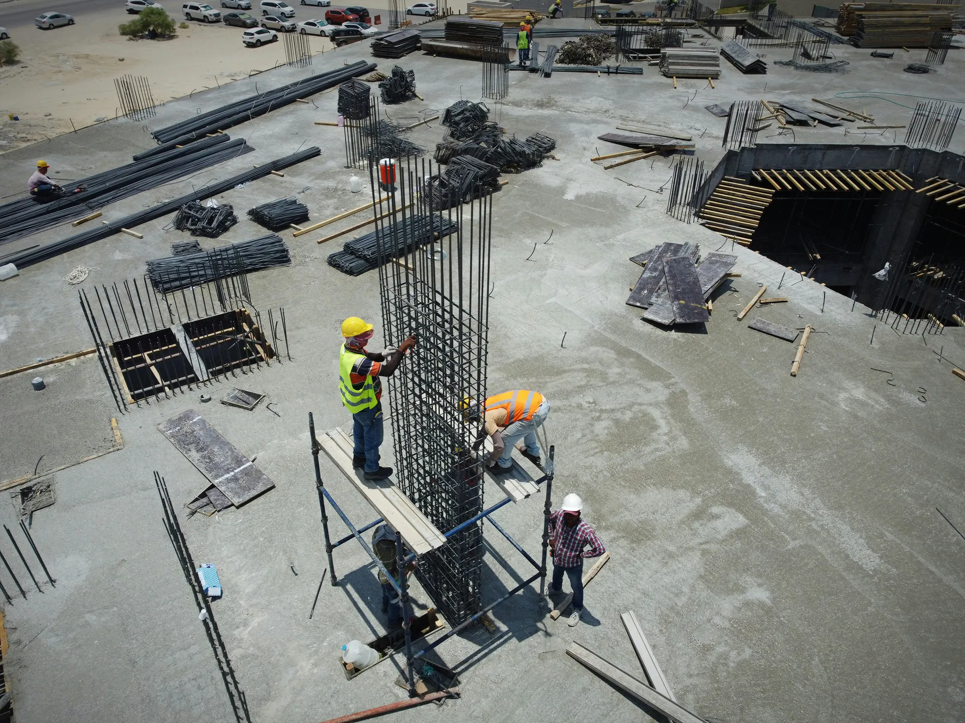 Workers reinforcing steel framework on a construction site – how to secure a construction site with safety measures and security planning.