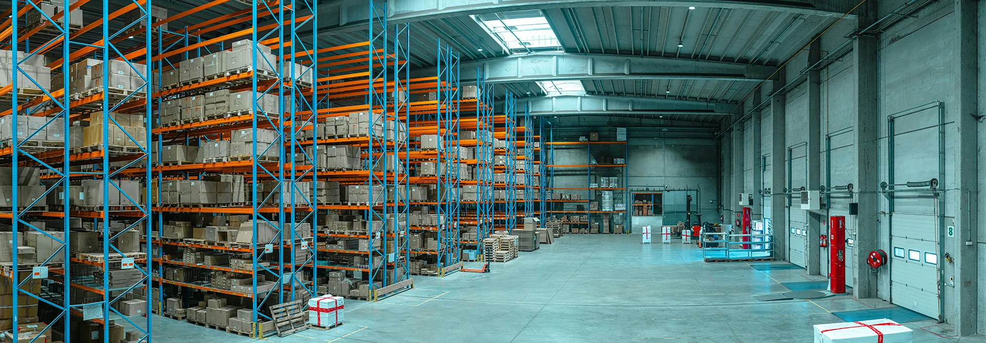 Modern warehouse interior with stacked inventory racks — highlighting the importance of security cameras and surveillance systems in warehousing.